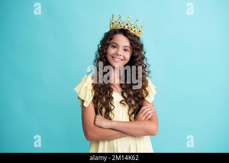 Portrait d'une jeune fille ambitieuse avec couronne, sensation de princesse, confiance. Couronne princesse enfant sur fond de studio isolé. Joyeux adolescent Banque D'Images