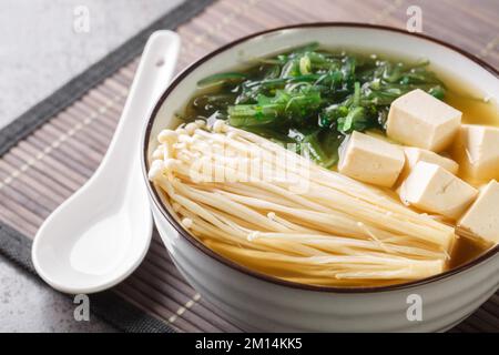 Soupe enoki Miso au tofu et aux algues dans un bol sur la table. Horizontale Banque D'Images