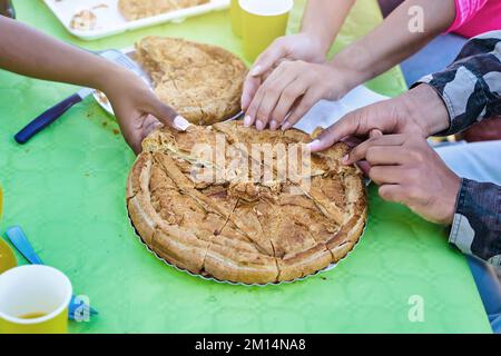 Mains ramasser la tarte au thon galicien qui est sur une table Banque D'Images
