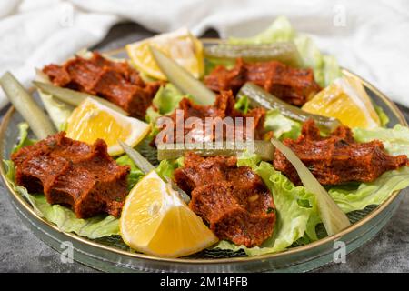 Boulettes de viande crues (cog kofte) sur fond sombre. Spécialités turques. gros plan Banque D'Images