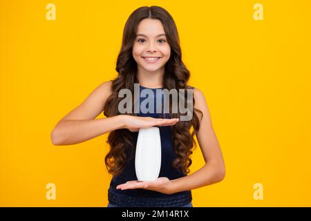Enfant avec après shampooing. Soins cosmétiques quotidiens. L'adolescent de 12, 13, 14 ans tient une bouteille de soins pour les cheveux et la peau. Beauté santé et cosmétiques Banque D'Images