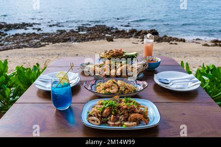 Table de dîner avec cuisine thaïlandaise et poisson barbecue sur la plage de Pattaya Thaïlande. Banque D'Images