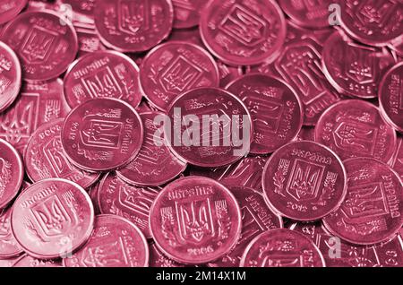 Une grosse pile de pièces d'une banque ukrainienne. Pièces de type ukrainien: Kopeck. Image tond en Viva Magenta, couleur de l'année 2023 Banque D'Images