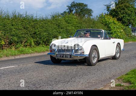 Années 1964 60 Sixties White TRIUMPH TR4 2138cc essence Cabriolet cabriolet ; en route pour Capesthorne Hall Classic May car show, Cheshire, Royaume-Uni Banque D'Images