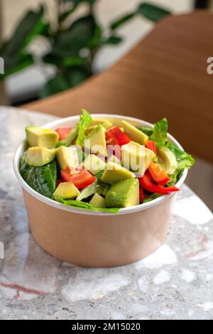 Salade d'avocats et de tomates fraîches dans un bol sur fond de pierre grise vue de dessus. Concept alimentaire pour les Parties. Restauration rapide. Déjeuner sain. Livraison de nourriture en dispo Banque D'Images