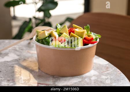 Salade d'avocats et de tomates fraîches dans un bol sur fond de pierre grise vue de dessus. Concept alimentaire pour les Parties. Restauration rapide. Déjeuner sain. Livraison de nourriture en dispo Banque D'Images