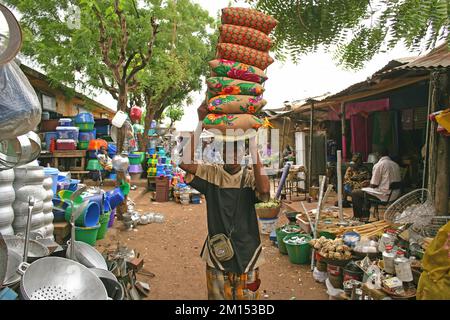 L'homme africain porte une pile d'oreiller sur sa tête à Bamako, Mali Banque D'Images