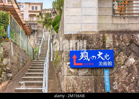 kyushu, nagasaki - décembre 14 2021: Panneau d'information menant au musée Kazenodaichi par une pente raide avec des escaliers étroits montant entre Japane Banque D'Images