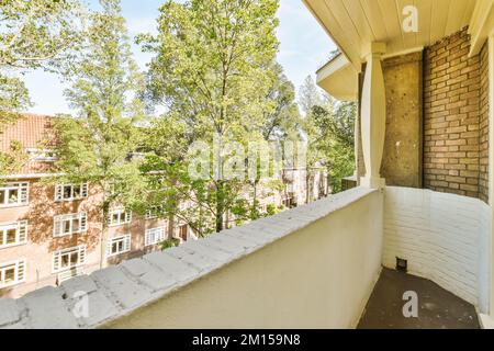 un balcon d'appartement avec des arbres et des bâtiments en arrière-plan sur une photo lumineuse de jour ensoleillé prise de notre fenêtre de balcon Banque D'Images