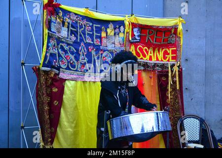 Manchester, Royaume-Uni, 10th décembre 2022. La vie quotidienne à Manchester, Angleterre, Royaume-Uni. Un batteur se trouve devant des bannières disant: 'Free Assange' à Piccadilly Gardens, centre de Manchester, Angleterre, Royaume-Uni. Il s'agit de Julian Assange, qui a formé un recours contre son extradition du Royaume-Uni devant la haute Cour et a formé un autre recours devant la Cour européenne des droits de l'Homme. Le 20 avril 2022, le tribunal des magistrats de Westminster a approuvé l'extradition d'Assange aux États-Unis. Le Ministre de l'intérieur, Priti Patel, a ensuite approuvé l'extradition. Crédit : Terry Waller/Alay Live News Banque D'Images