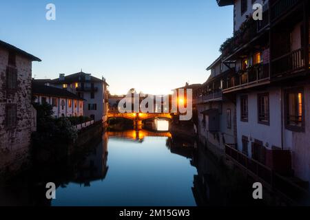 Vue au coucher du soleil sur le pont principal au-dessus de la Nive sur son chemin à travers le village de Saint Jean pied de Port célèbre place de la voie de Saint James Banque D'Images