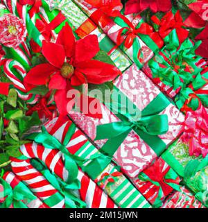 Forfaits cadeaux des fêtes, emballés avec des rubans et des noeuds. poinsettia, canne à sucre, groupe de tête vert et rouge. Banque D'Images