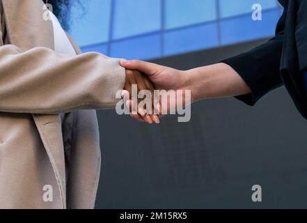 Vue latérale des femmes d'affaires sans visage différentes qui se mêle comme symbole de la réussite d'une réunion de négociation dans le centre-ville Banque D'Images