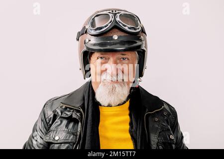 Portrait d'un motard homme barbu en cuir et d'un casque de moto souriant, en regardant la caméra isolée sur fond blanc Banque D'Images