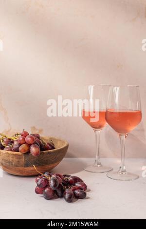 Verres de boisson rouge placés sur la table avec un bol de raisins et de figues Banque D'Images