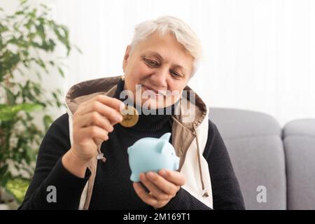 Gros plan d'une femme âgée tenant une caisse d'argent de porc. Femme âgée mains tenant une porcgybank. Concept d'économie d'argent pour les personnes âgées. Banque D'Images