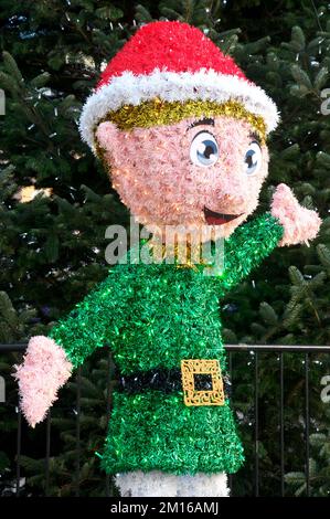 Le petit aide du Père Noël. Une bande dessinée étincelante d'un orf de Noël avec guirlande et lumières de fées dans le principal quartier commerçant de Weymouth dans le Dorset. Banque D'Images