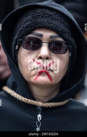 Istanbul, Turquie. 10th décembre 2022. La bouche d'une protestataire est peinte en rouge en forme de croix pendant la manifestation. La mort de Mahsa Amini a suscité des semaines de manifestations violentes en Iran et dans d'autres pays. Mahsa est tombé dans le coma et est mort après avoir été arrêté à Téhéran par la police de moralité pour avoir prétendument violé les règles du hijab du pays. Dans les procès concernant les manifestations, 11 personnes ont été condamnées à mort jusqu'à présent. Crédit : SOPA Images Limited/Alamy Live News Banque D'Images