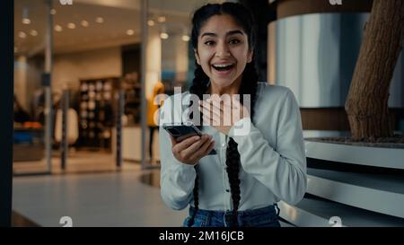 Happy girl Woman acheteur shopping en ligne à l'application mobile gagner des remises entreprise bénéfice célébrer la réalisation faire les pouces vers le haut geste recommander téléphone moderne Banque D'Images