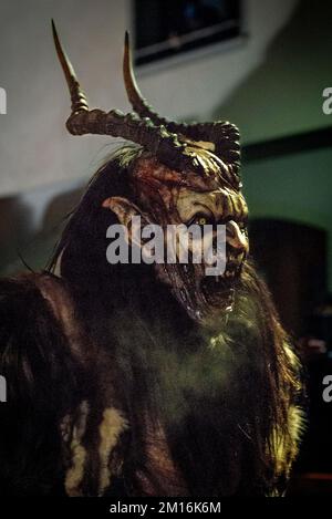 Les monstres masqués de diable défilent dans le village en écartant la foule tout en gardant vivante cette tradition alpine folklorique Banque D'Images