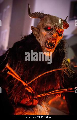 Les monstres masqués de diable défilent dans le village en écartant la foule tout en gardant vivante cette tradition alpine folklorique Banque D'Images