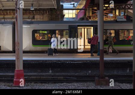 Les passagers du train attendent devant un train London North Western Railway à la gare de Crewe sur la ligne principale de la côte ouest Banque D'Images