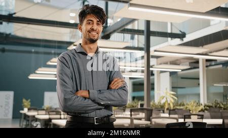 Homme d'affaires indien souriant et confiant, homme analyste financier, employé, travailleur professionnel, debout au bureau avec des armes croisées, le beau adulte arabe inv Banque D'Images