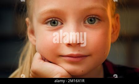 Gros plan portrait petite fille mignon angélique blonde fille avec de grands yeux verts beau caucasien enfant preschooler adorable petit modèle regardant la came Banque D'Images