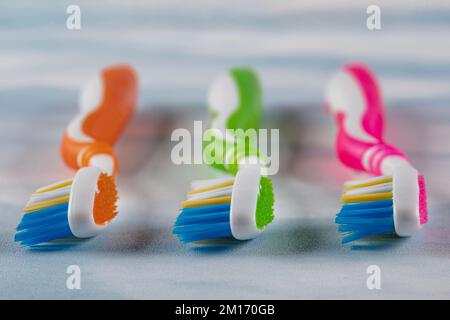 Brosses à dents en plastique avec poignées colorées sur fond de couleur. Banque D'Images