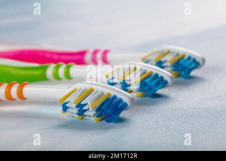 Brosses à dents en plastique avec poignées colorées sur fond de couleur. Banque D'Images
