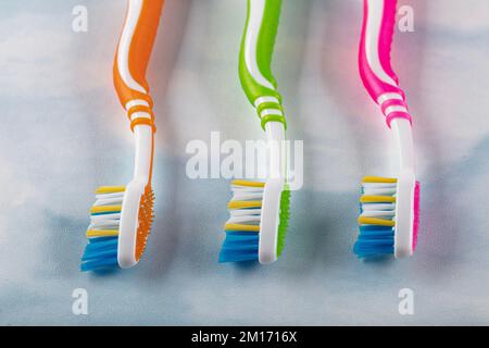 Brosses à dents en plastique avec poignées colorées sur fond de couleur. Banque D'Images