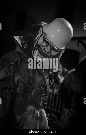 Les monstres masqués de diable défilent dans le village en écartant la foule tout en gardant vivante cette tradition alpine folklorique Banque D'Images