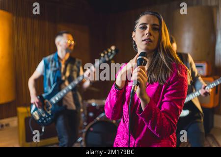 image rognée d'un groupe musical de jeunes, d'un chanteur devant et de guitaristes jouant dans le concept musical de fond. Photo de haute qualité Banque D'Images