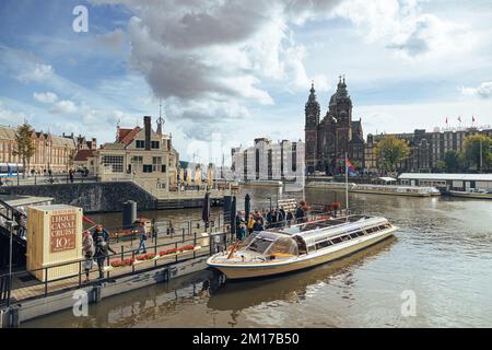 Amsterdam - 02 octobre 2022 - touristes sur le bateau près de la gare centrale en face de la basilique Saint-Nicolas. Banque D'Images