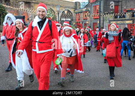 Londres, Royaume-Uni, 08th décembre 2022. Le groupe passe devant « The Anchor », l'un des plus anciens pubs de Londres sur la Tamise. Les Santas marchent à travers Borough Market et le long de la Tamise sur la rive sud de Londres. Des centaines de Jolly Santas se joignent à l'édition 2022 de London SantaCon, un congrès annuel à but non lucratif qui voit les donateurs présents de Laponie marcher le long de diverses routes à Londres qui se rejoignent habituellement à Trafalgar Square. La marche permet de gagner de l'argent pour la charité. Le SantaCon de cette année est plus petit et moins exhuberant que les années précédentes, après plusieurs années d'absence pendant la pandémie de covid. Banque D'Images