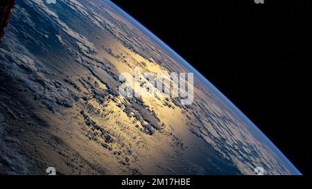 Vue aérienne de la terre et des nuages dans l'atmosphère au-dessus de l'océan Atlantique avec la lumière du soleil qui glinent sur la mer. Éléments de cette image fournis par NAS Banque D'Images