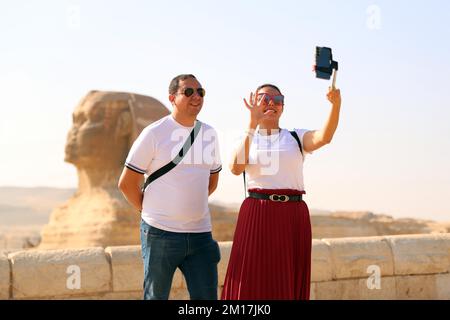 Giza, Égypte. 10th décembre 2022. Les touristes prennent un selfie près du Sphinx à l'endroit pittoresque des Pyramides de Gizeh, Egypte, 10 décembre 2022. L'Egypte a vu un nombre croissant de touristes sur ses sites archéologiques pendant la haute saison pour le tourisme en hiver. Credit: Ahmed Gomaa/Xinhua/Alamy Live News Banque D'Images