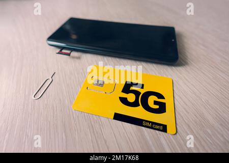 Carte SIM étiquetée 5g. Remplacement d'une carte SIM dans un téléphone portable avec Internet haut débit. Banque D'Images