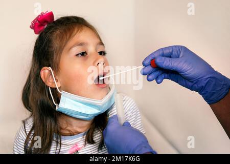 Médecin faisant le coronavirus covid 19 Test pour fille patient. Prélèvement d'un échantillon de salive d'un homme. Test d'ADN. Collection de mucus de la gorge pour la recherche Banque D'Images