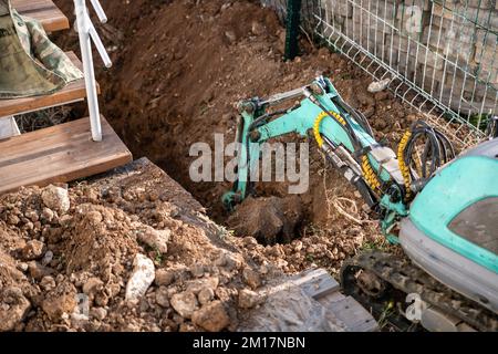 Une minipelle creuse une tranchée pour poser les tuyaux. Gros plan d'une pelle hydraulique creusant une tranchée profonde. Une pelle hydraulique creuse une tranchée dans la campagne pour déposer un Banque D'Images