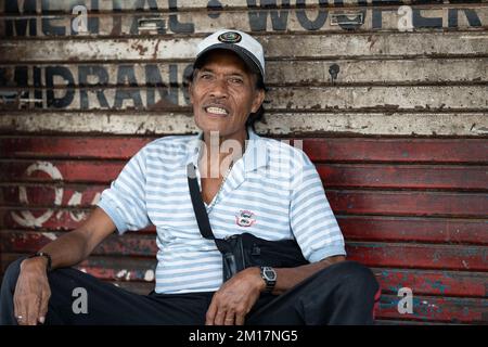 Portrait environnemental d'un philippin, assis sur une petite rue, Cebu City, Philippines Banque D'Images