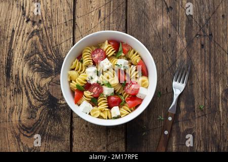 Salade maison avec pâtes, tomates, feta et épices sur table en bois. cuisine simple et délicieuse. vue de dessus, espace Banque D'Images