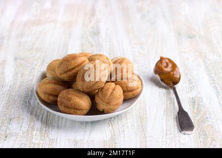 Pâtisseries sucrées traditionnelles russes faites maison, noix de shortbread et lait concentré sur un fond en bois Banque D'Images