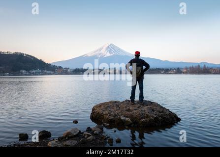 Homme profitant de la vue du lever du soleil sur le Mont Fuji, rive nord du lac Kawaguchiko, Japon. Banque D'Images