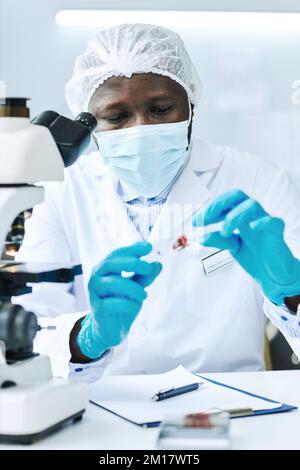 Portrait vertical d'un scientifique afro-américain effectuant des analyses de sang en laboratoire médical à la clinique Banque D'Images