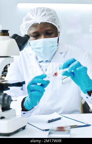 Portrait vertical d'un scientifique afro-américain effectuant des analyses de sang en laboratoire médical à la clinique Banque D'Images