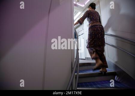 Une hôtesse d'air desservant les deux étages d'un avion. Banque D'Images