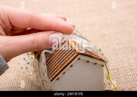 Petit modèle chambre enveloppée de tissu sur un fond brun Banque D'Images