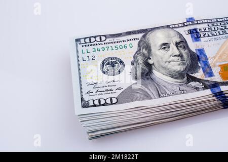 Billets américains de 100 dollars en papier placés sur fond blanc Banque D'Images