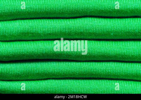 TEXTURE D'ARRIÈRE-PLAN - morceaux pliés de tissu tricoté vert Banque D'Images